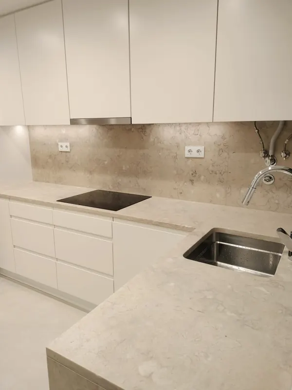 Remodelação de cozinha com bancada em pedra clara e placa de indução