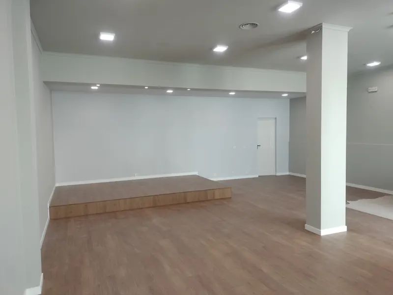 Depois: sala ampla em Cascais com estrado em madeira, coluna e paredes pintadas