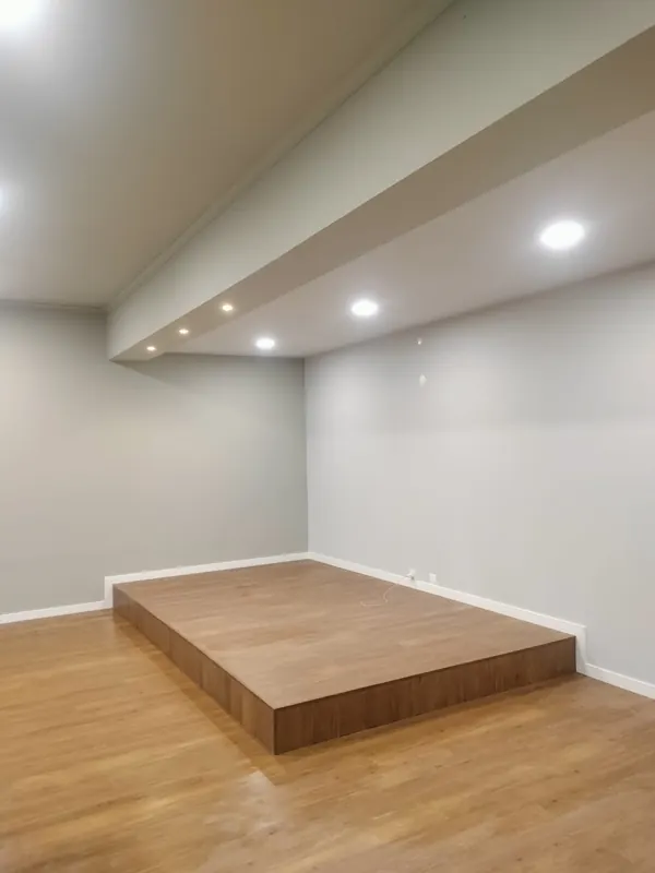 Sala com estrado em madeira e teto falso com focos