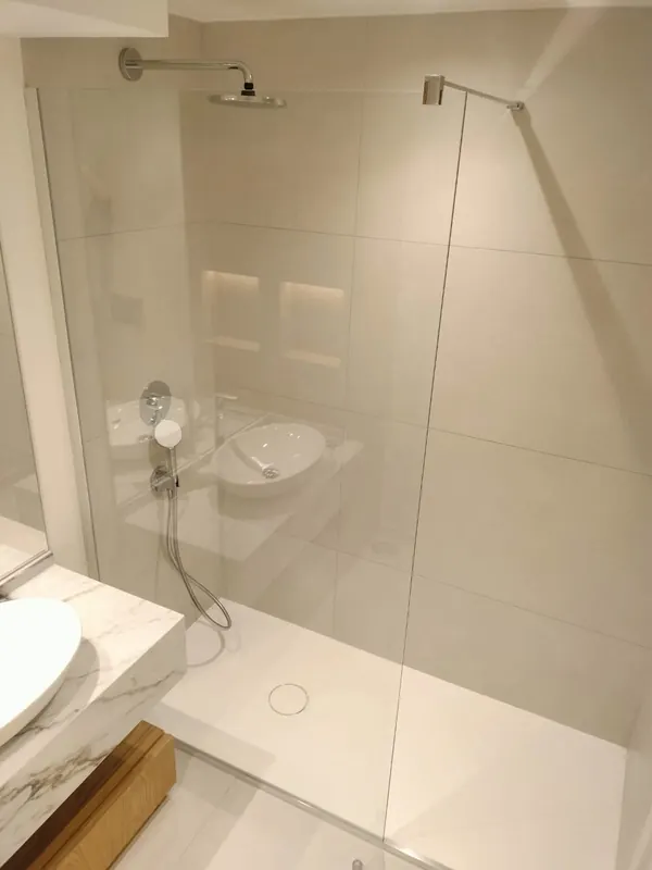 Duche com resguardo de vidro numa casa de banho remodelada